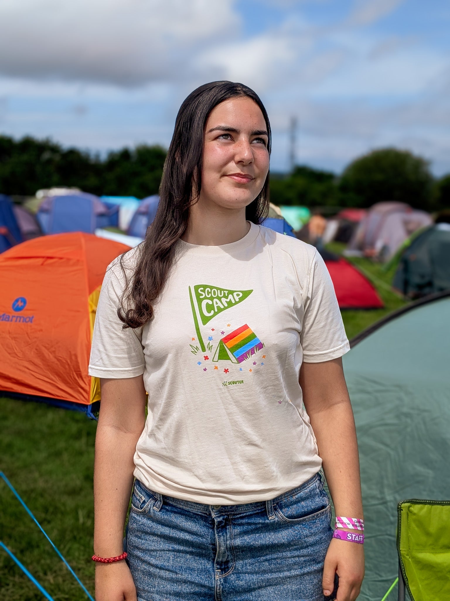 Person wearing a t-shirt with a Scout Camp print showing a Pride flag tent at a camping event